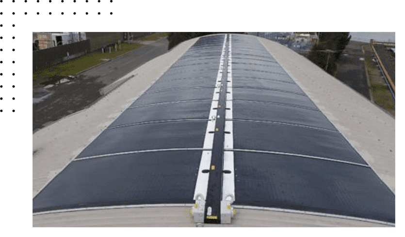 Curved solar panels on industrial rooftop.
